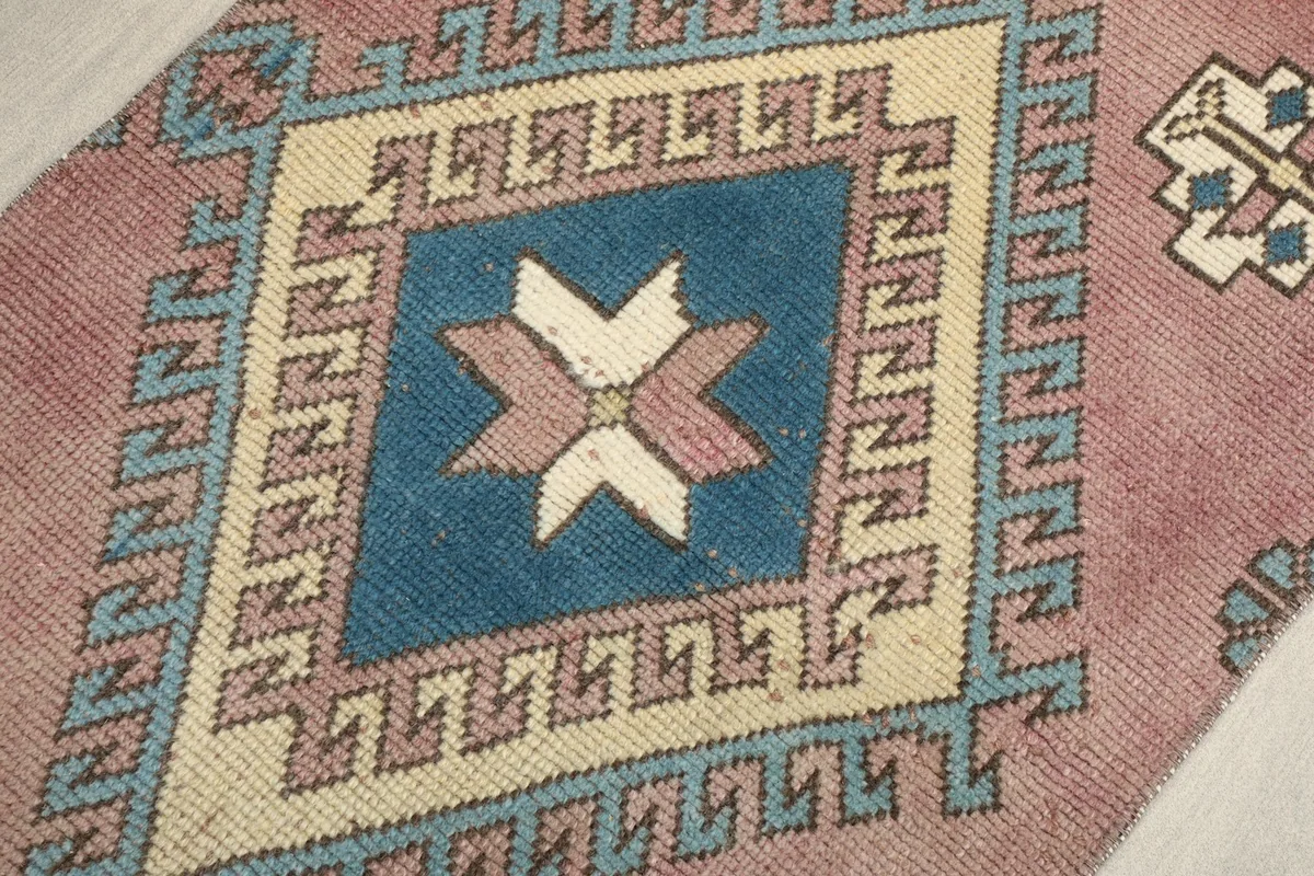 Detailed view of the central blue and ivory geometric medallion with rose accents.