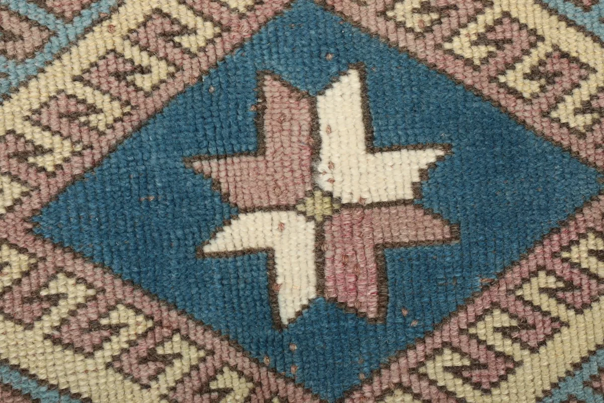Extreme close-up of the star-like motif within the central medallion, showing individual knots.