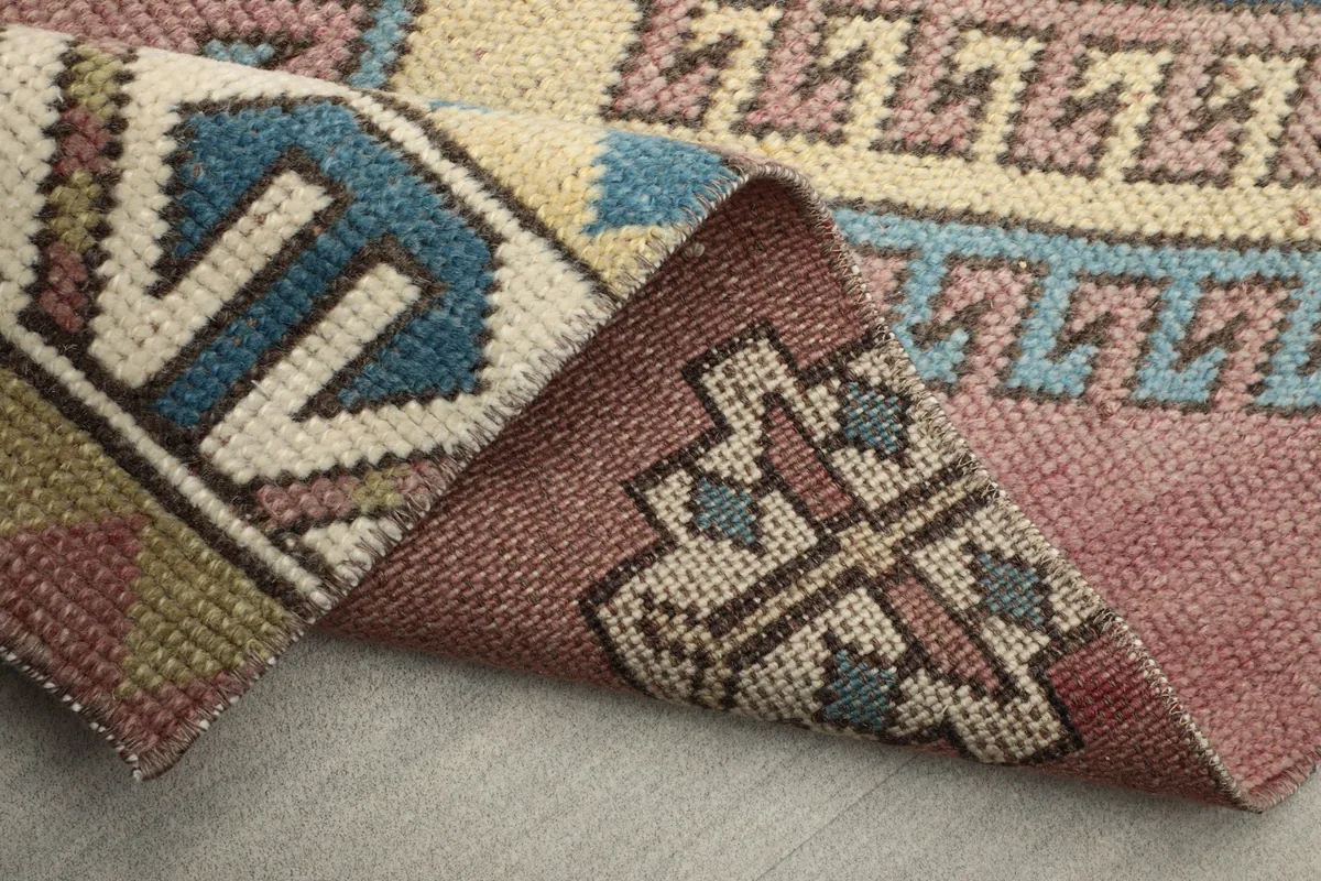 Another view of a folded corner, revealing the back weave and thickness of the hand-knotted rug.