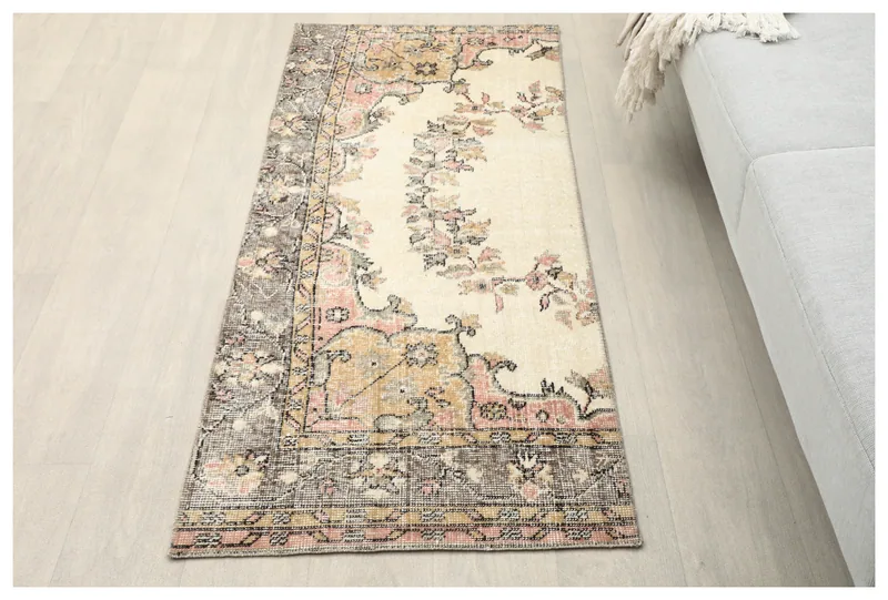 Full top view of the 2'1" x 5'2" ivory, rose, and gold floral vintage Anatolian runner on a white background.
