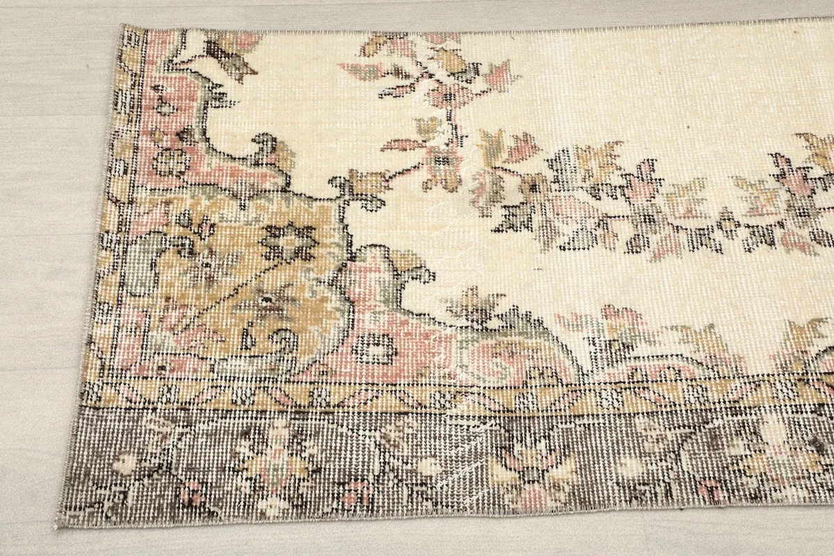 Detailed view of the rug's border and a section of the floral design, revealing the texture and varied colors.