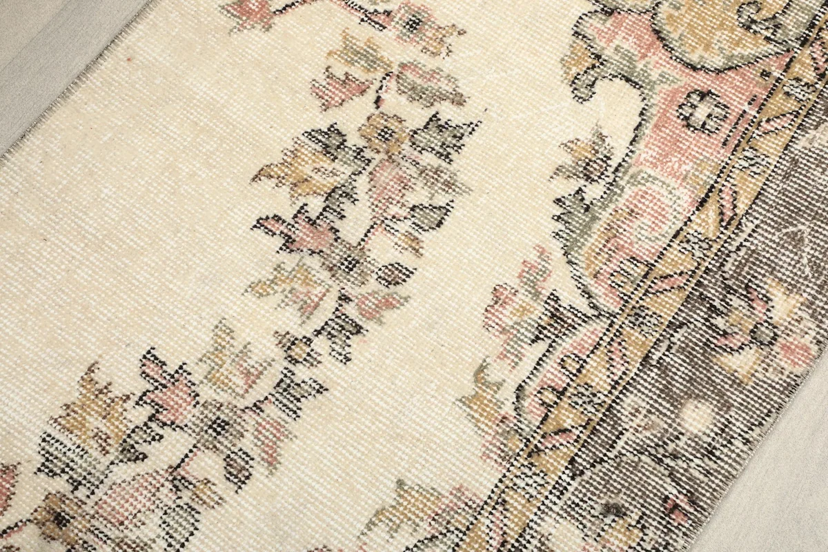 Close-up of the central floral vine pattern, displaying the delicate rose, gold, and gray hues.
