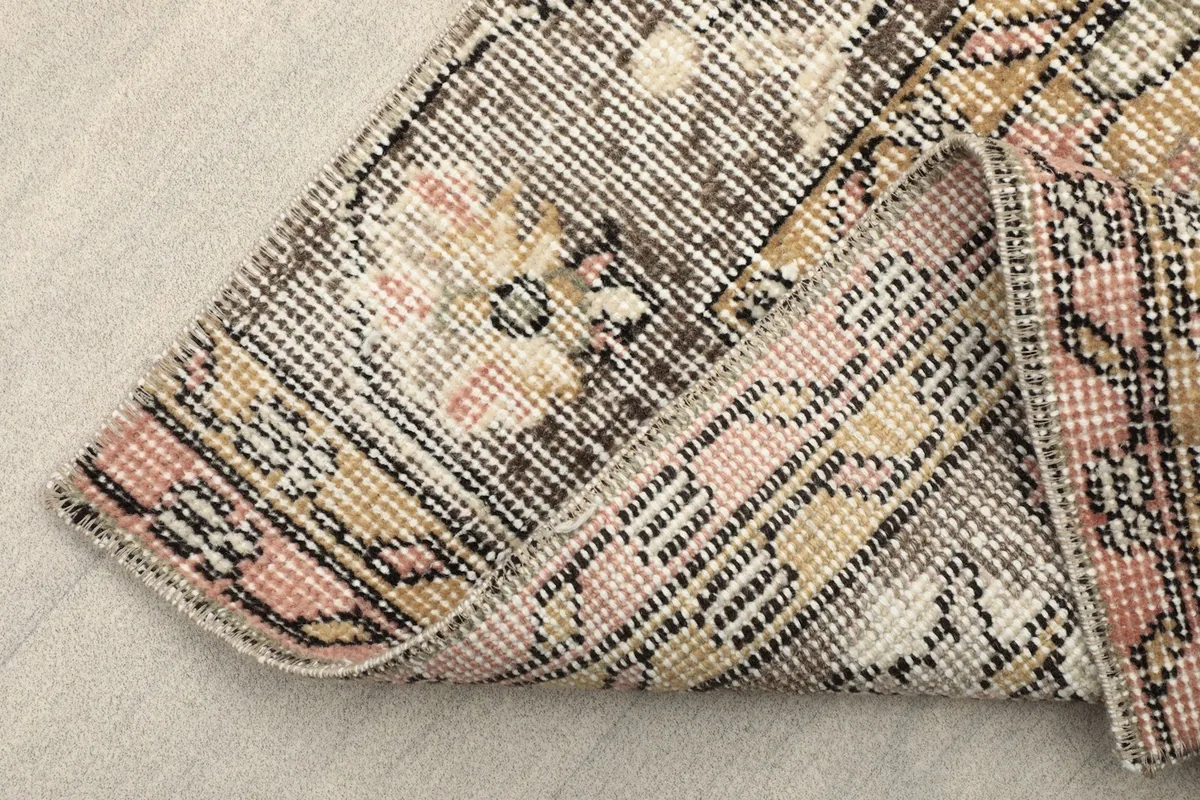 View of the rug folded to show the hand-knotted construction and the cotton foundation on the reverse side.