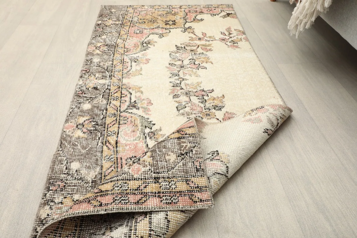 Partial fold of the rug, showing the flexibility and density of the hand-knotted wool pile and cotton foundation.