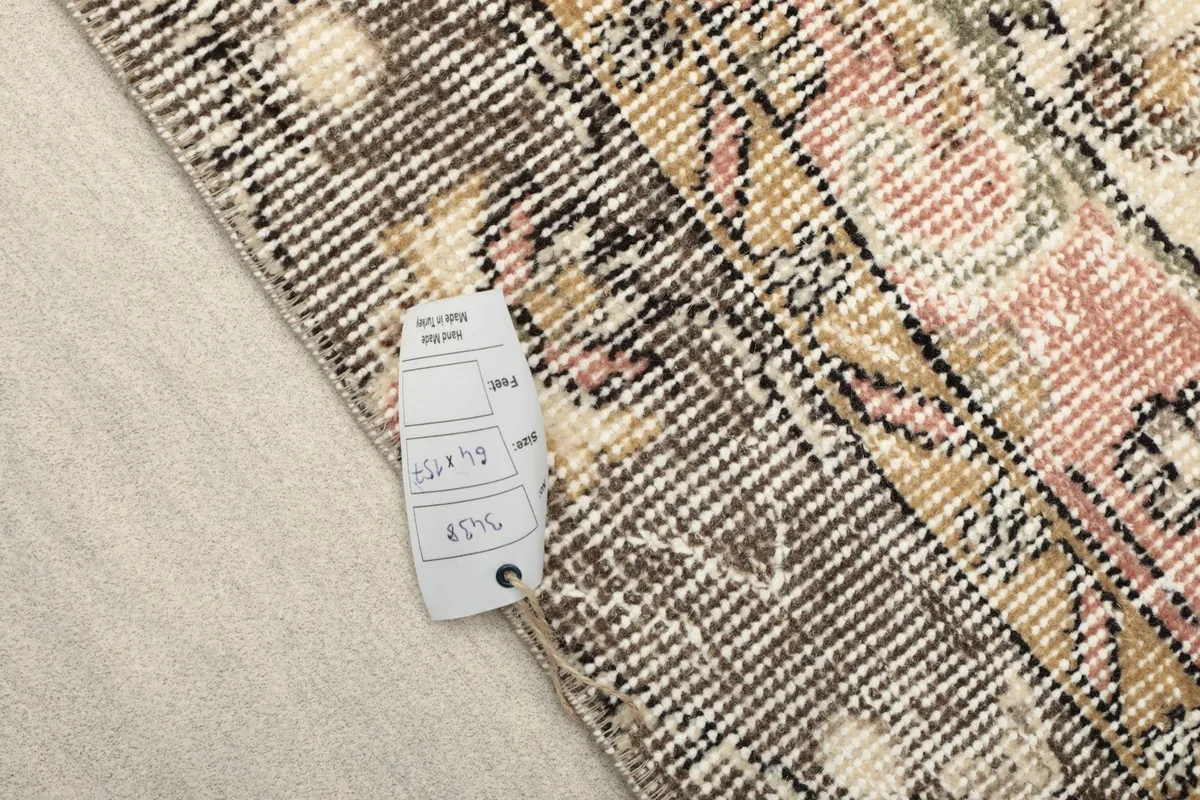 Close-up of a tag on the rug's back, indicating the unique product identification number and hand-knotted quality.