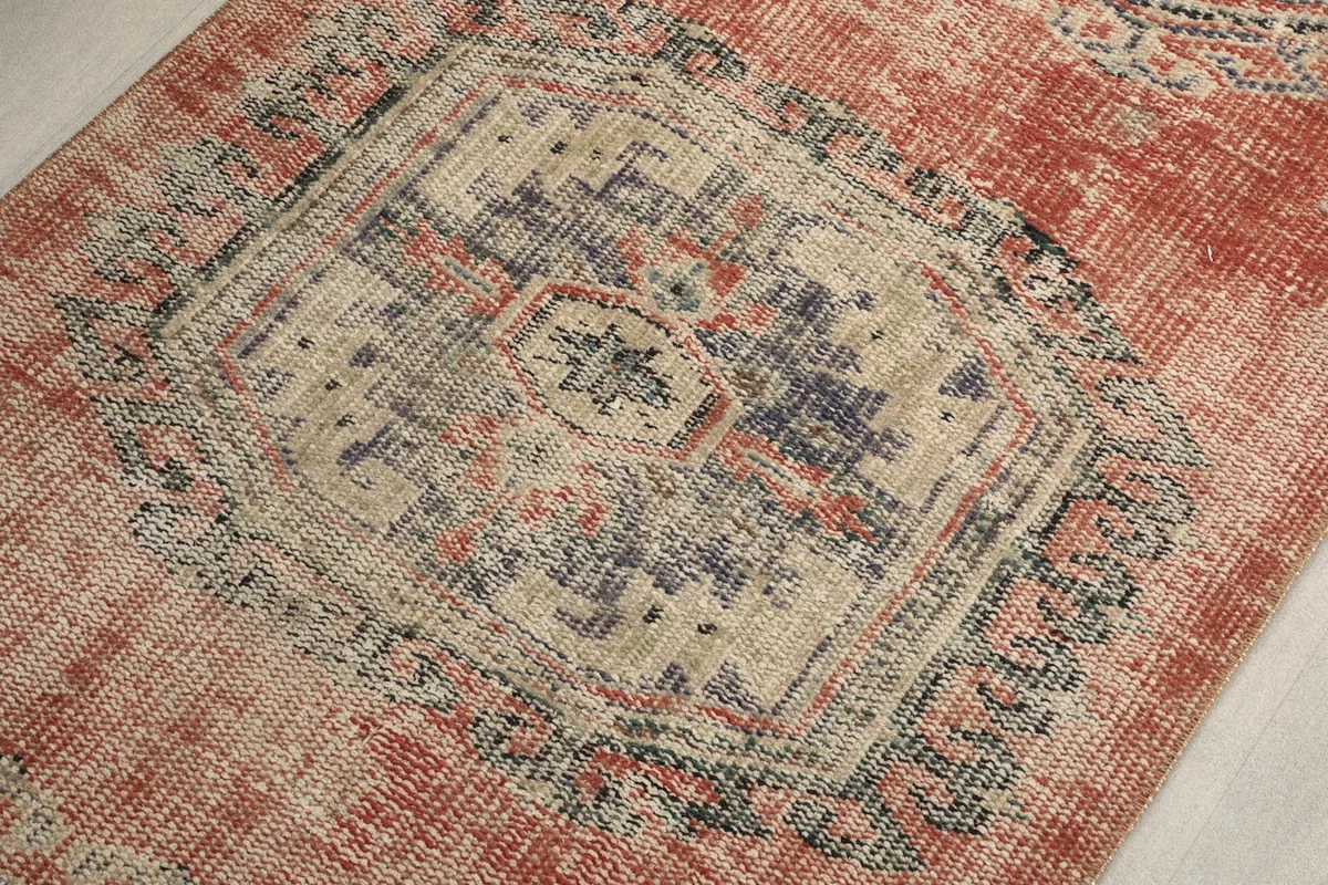 Close-up of a central medallion, highlighting the intricate geometric designs and worn patina.