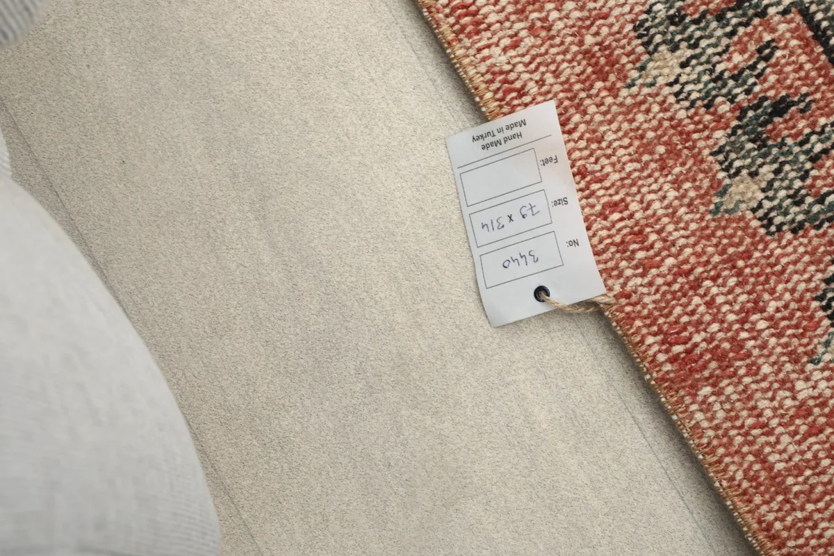 Close-up of a tag on the rug, indicating its origin and size specifications.