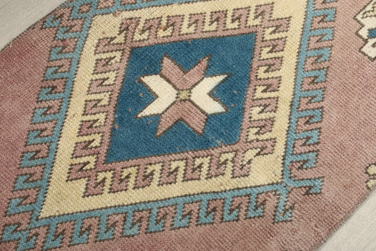 Detailed view of the central diamond motif, showcasing the blue field and star-like pattern.