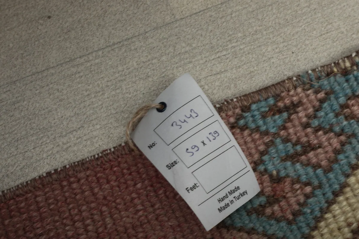 A tag showing the rug's product number 3443 and size 59 x 139 cm, confirming it is handmade in Turkey.