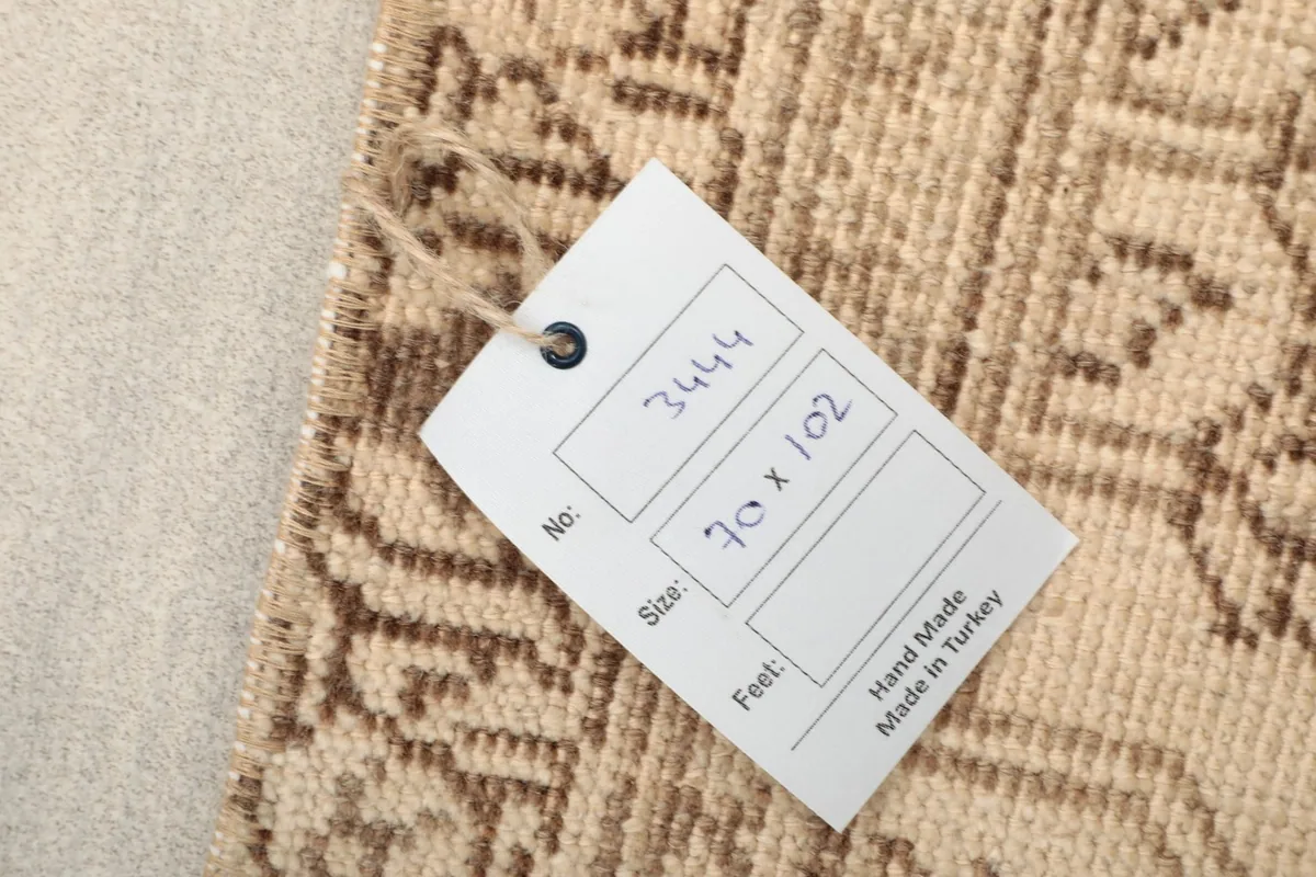 Close-up of the rug's back with a tag indicating 'Hand Made Made in Turkey' and size