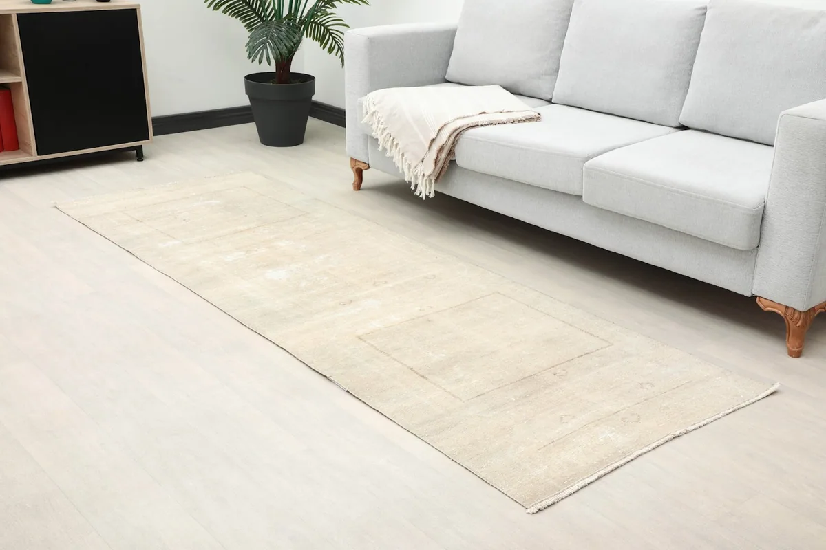 Close-up room view of the beige runner rug's texture and subtle geometric patterns