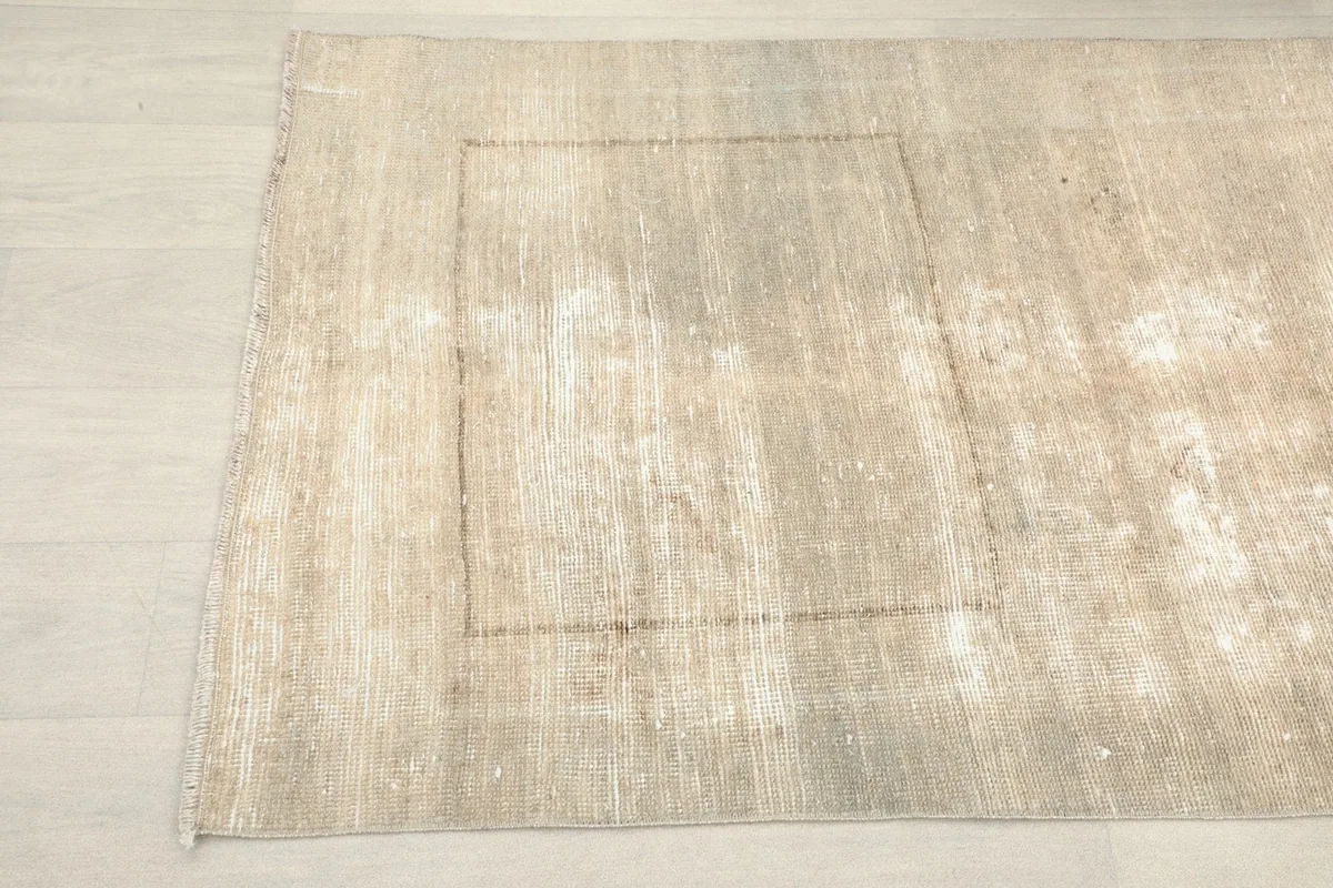 Close-up of the runner rug's surface, highlighting areas of gentle wear and light color variation