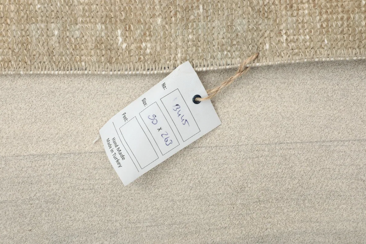 Product tag on the rug showing measurements and 'Hand Made in Turkey'