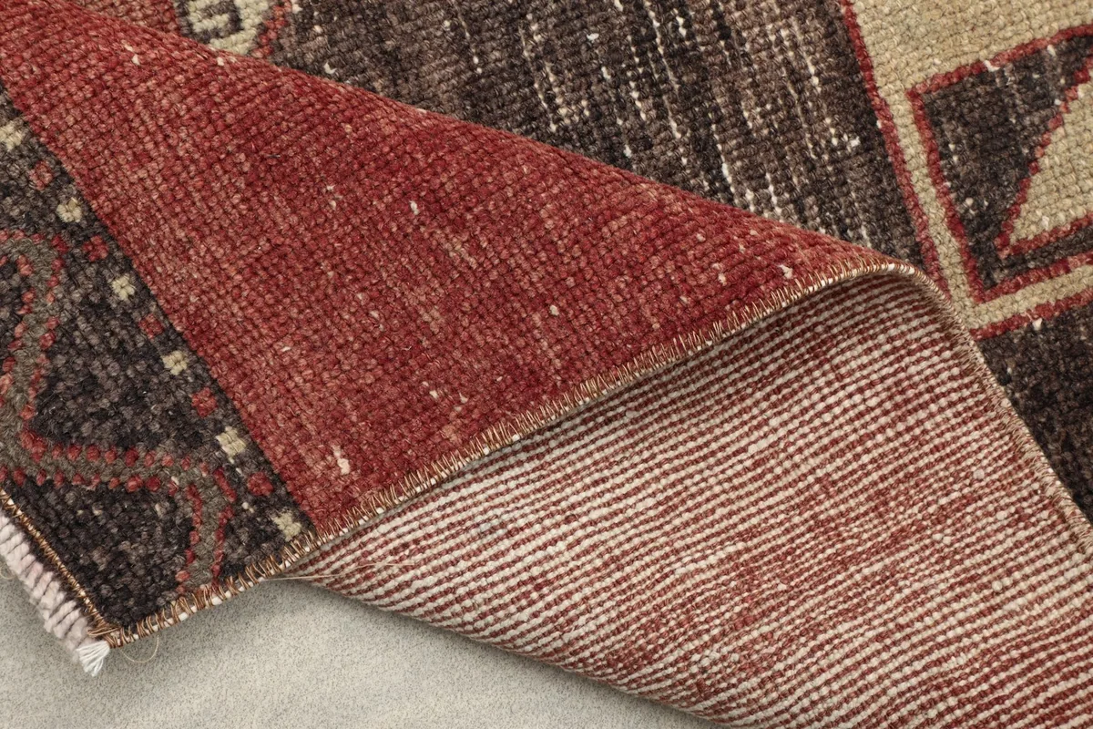 Close-up of the rug's reverse side, revealing the hand-knotted cotton foundation and pile structure