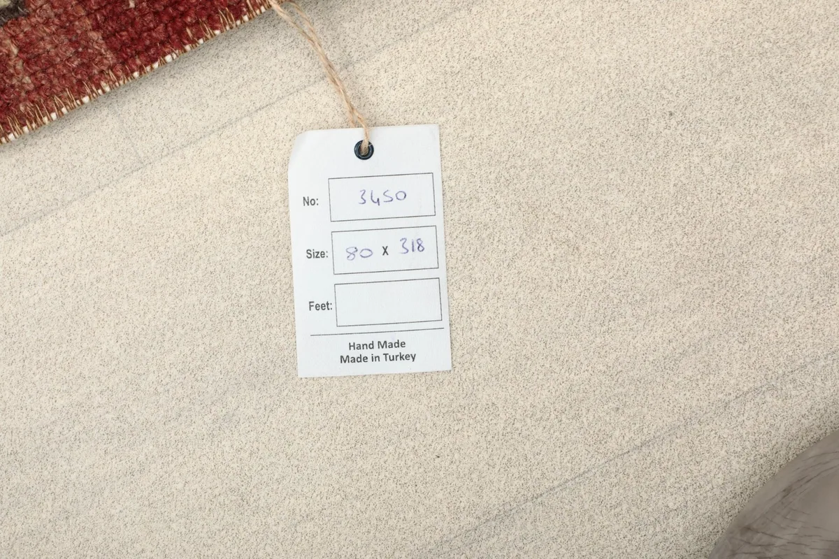 Product tag indicating the rug's handmade origin and size in centimeters