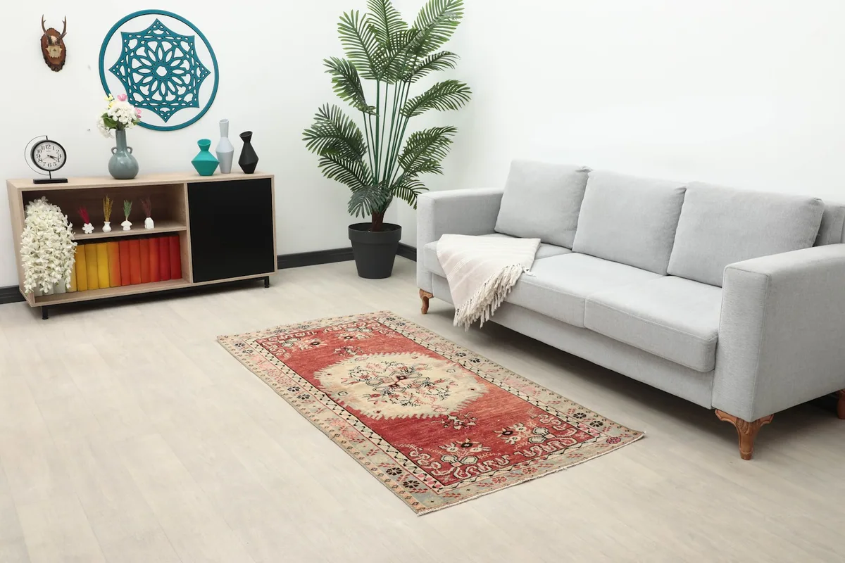 Full room view with the rug placed in front of a gray sofa and a wooden cabinet, showing scale.