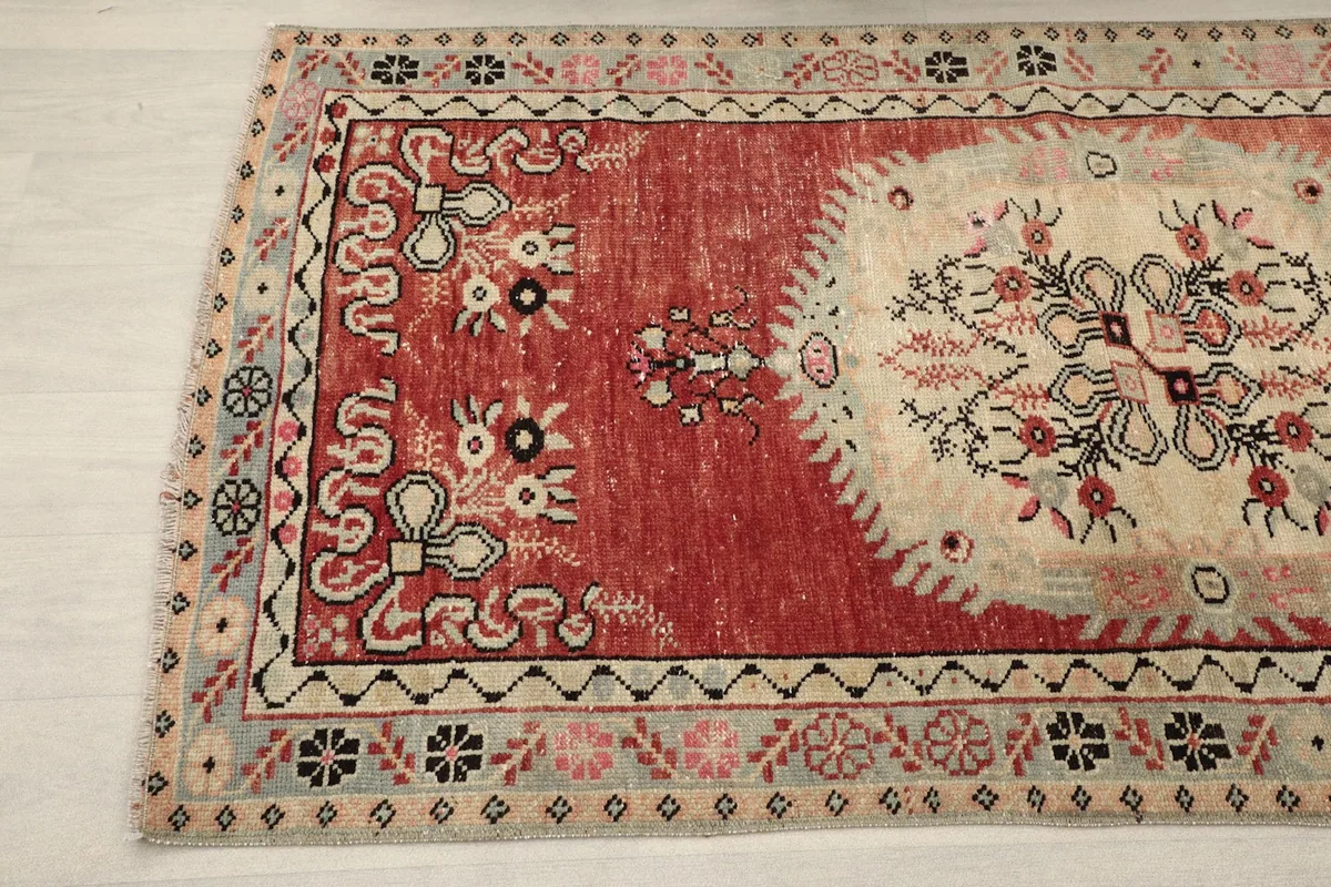 Detailed view of the rug's border and corner, showing the intricate geometric and floral motifs.