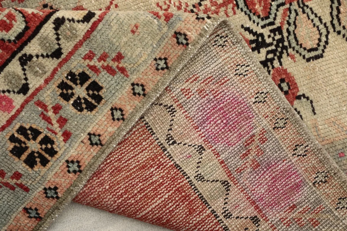 View of the rug's reverse side, showing the hand-knotted cotton foundation and wool pile construction.