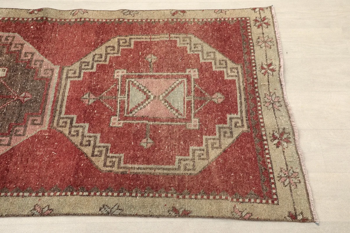 Section of the runner showing the beige border with small floral motifs and part of a main medallion.