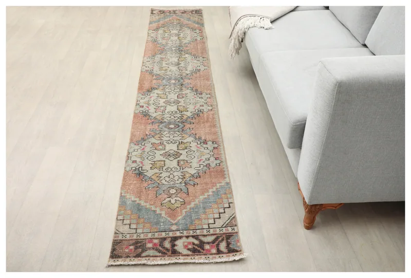Full top view of the 1'8" x 9'5" rust and gray geometric Anatolian runner rug on a white background.