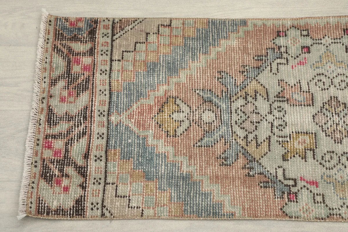 Close-up detail of the center pattern and border, showing intricate geometric designs and color variations.
