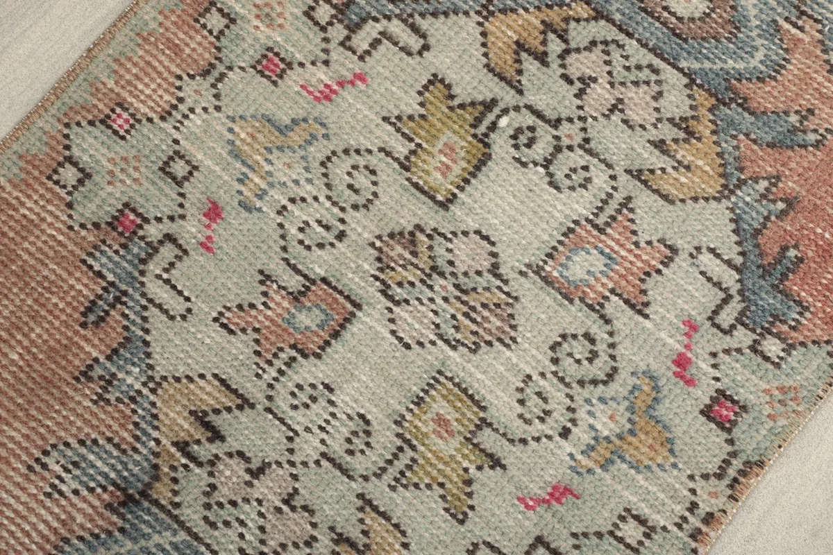 Detailed view of the central gray medallion-like motif with surrounding rust and blue patterns.