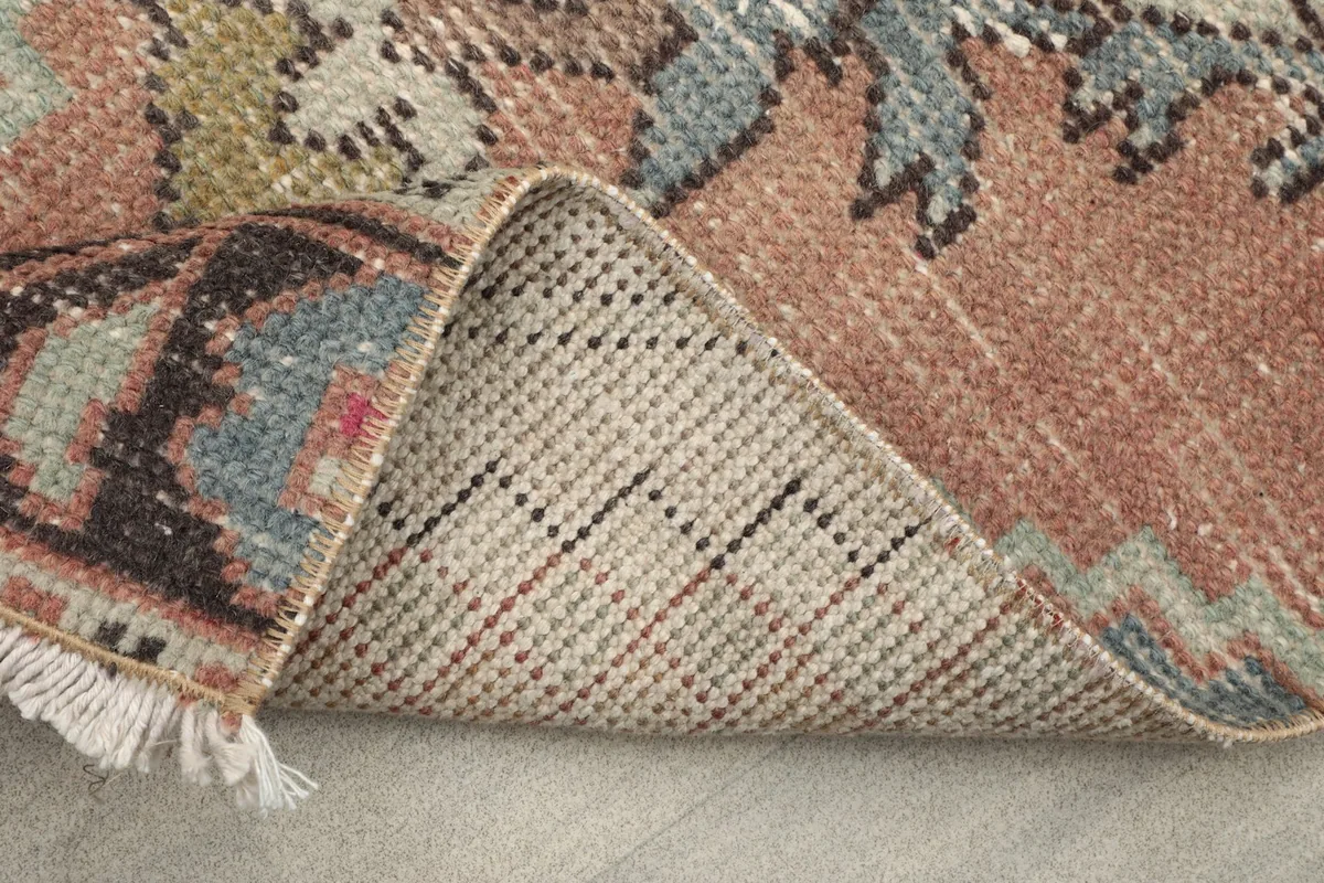 View of the back of the rug, illustrating the dense hand-knotting and cotton foundation.