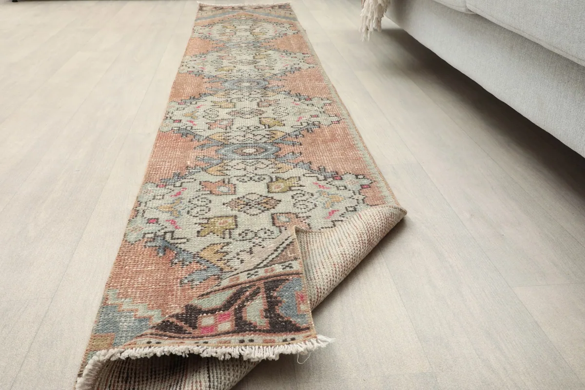 The runner rug partially folded, showing its flexibility and the texture of the pile.