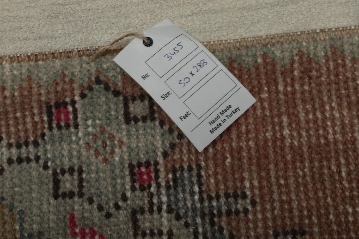 Close-up of the rug's tag, indicating its dimensions (50x288 cm) and origin from Turkey.