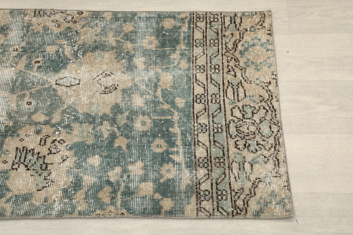 Close-up of the rug's border design featuring geometric patterns in tan and black