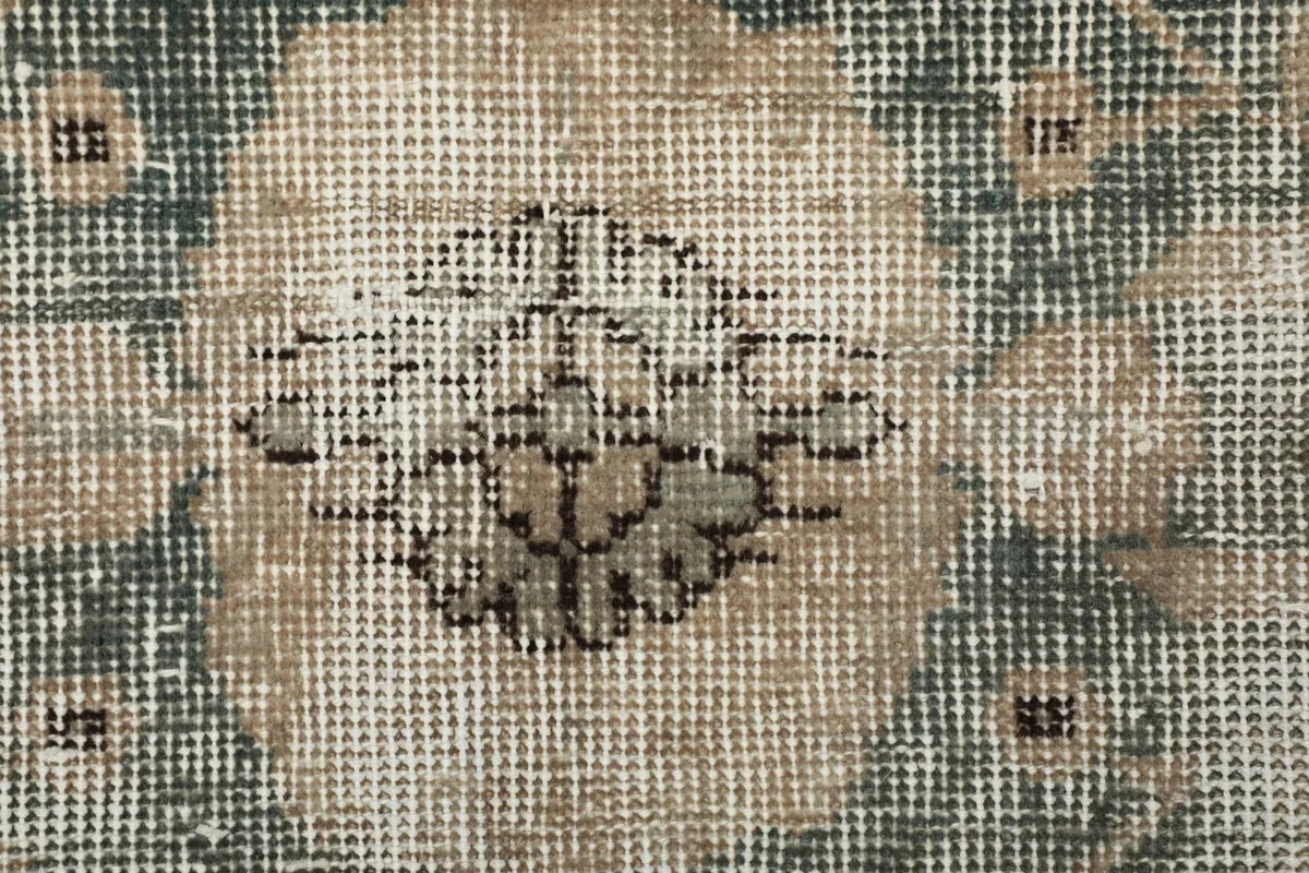 Extreme close-up of the low wool pile and hand-knotted texture of the rug
