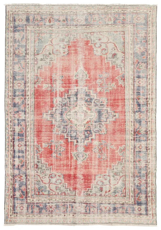 Full overhead view of the vintage red and navy medallion rug on a white background.