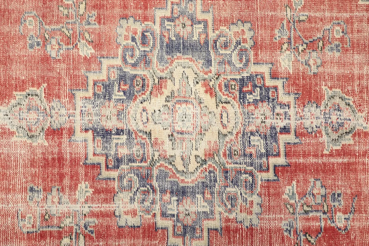Close-up of the central navy medallion and surrounding red field with subtle patterns.