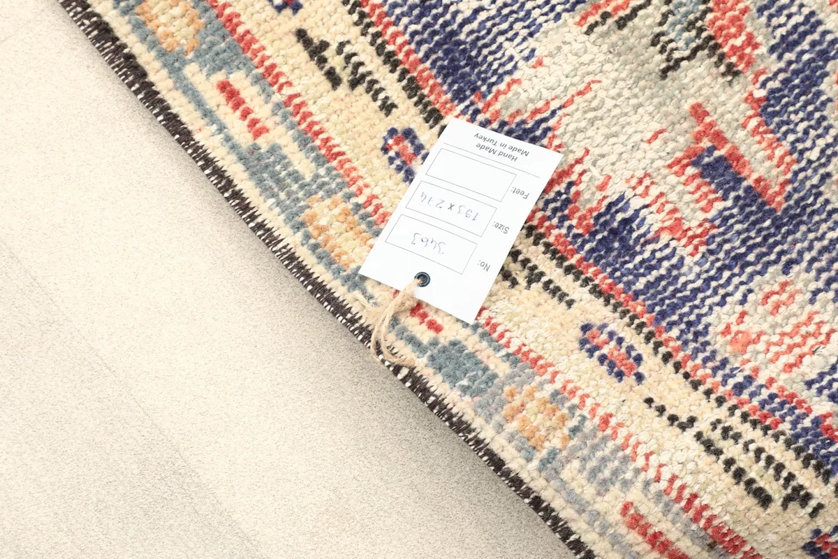 View of the rug's reverse side, showing the hand-knotted construction and care tag.