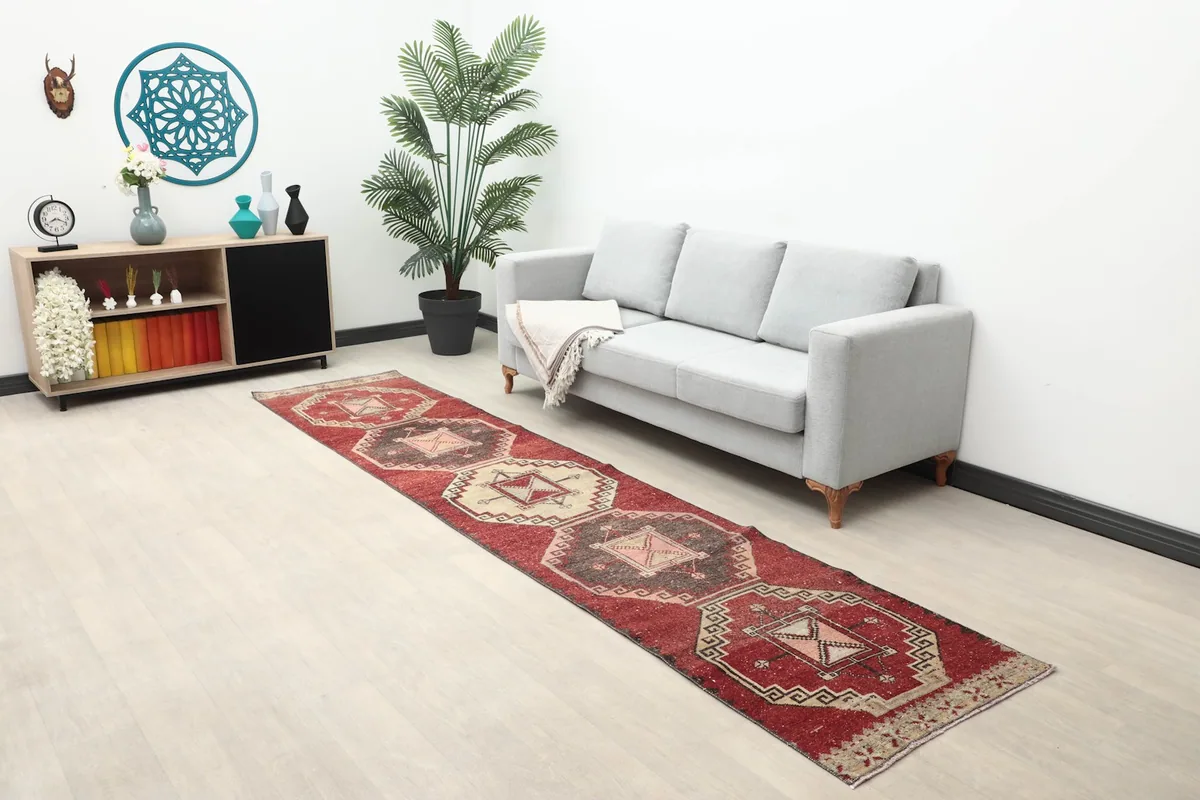 Wide shot of the red geometric runner rug in a room with a sofa and decor, showing overall scale