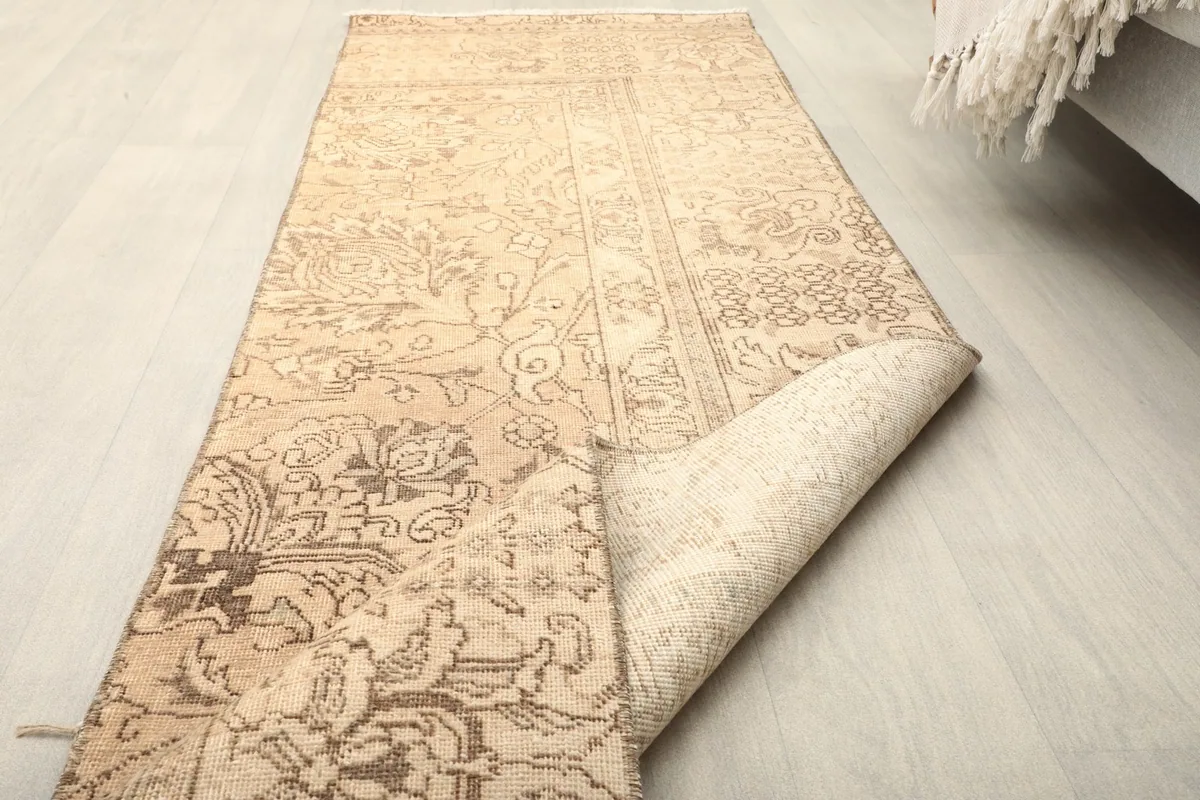 The runner rug partially folded, showing the flexibility and thickness of the vintage wool.