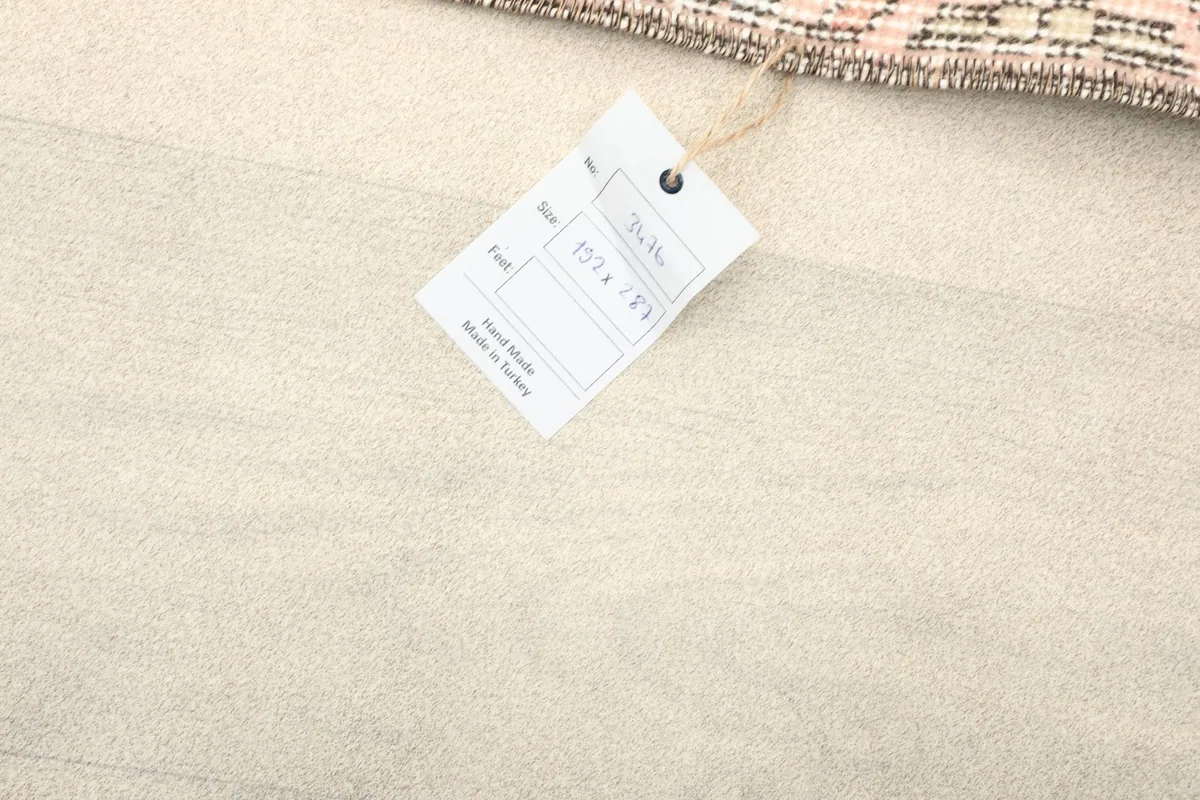 Rug tag with product information, indicating its origin and size on a light wooden floor