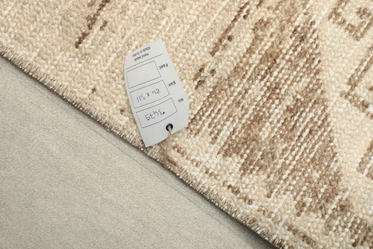 Close-up of the rug with a tag showing its dimensions and origin details