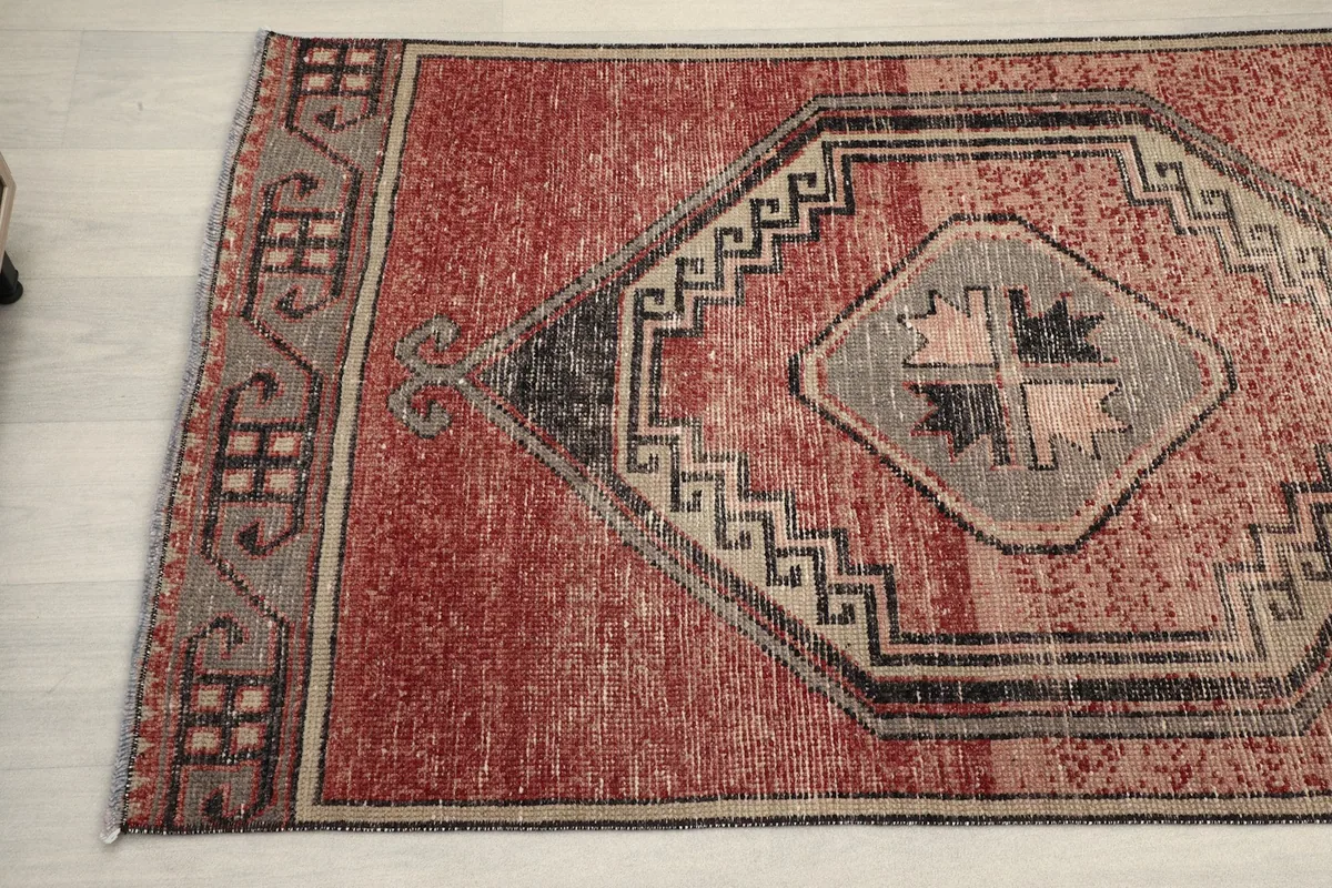 Angled shot of the rust runner, focusing on the intricate geometric patterns and the distressed appearance.