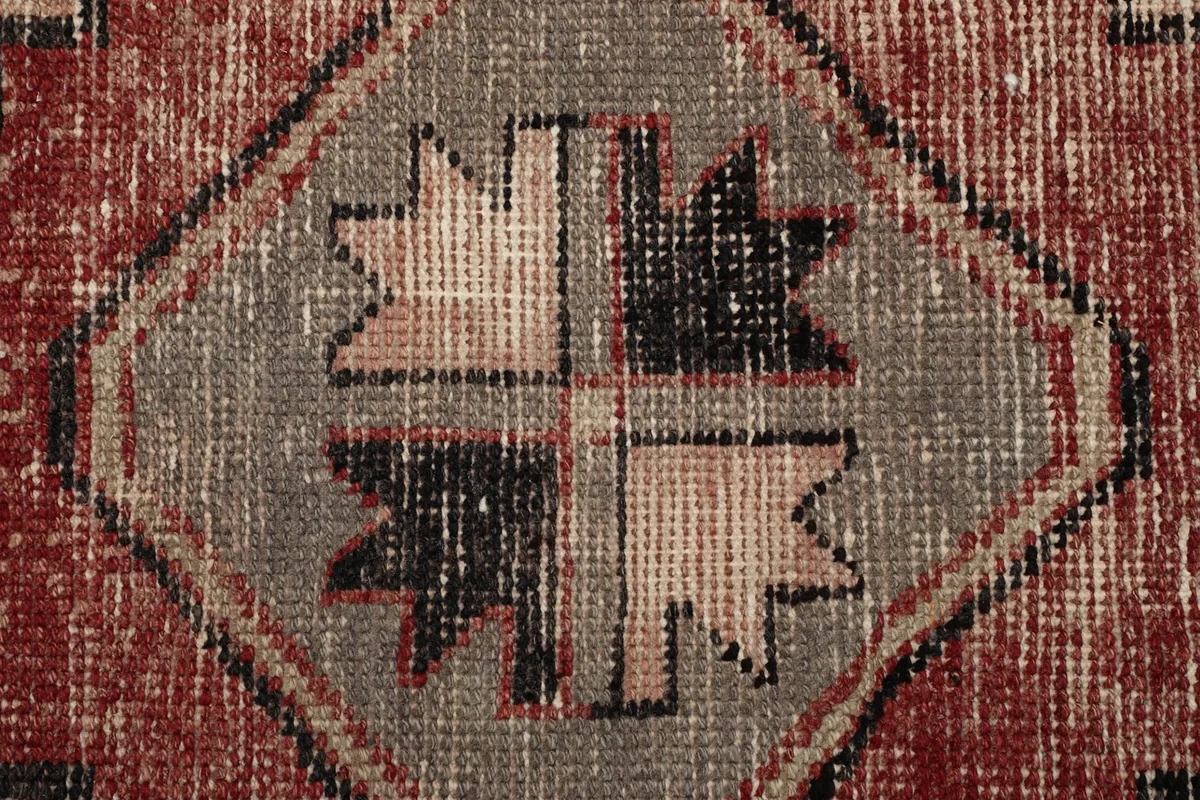 Extreme close-up of a geometric motif within a medallion, showing the hand-knotted wool pile and color variations.