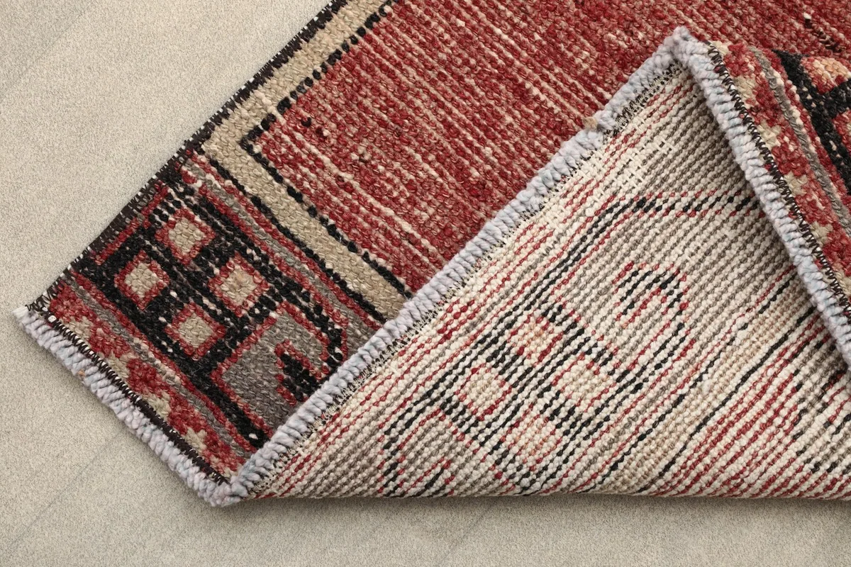 Corner view showing the reverse side of the rug, revealing the cotton foundation and hand-knotted construction.