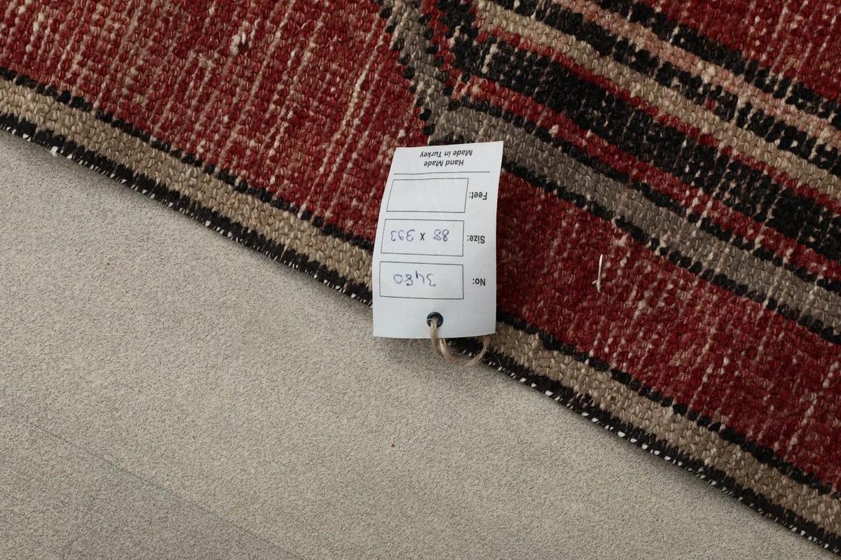 Detail of the rug with a size tag, showing the 88 x 393 cm dimensions and origin.