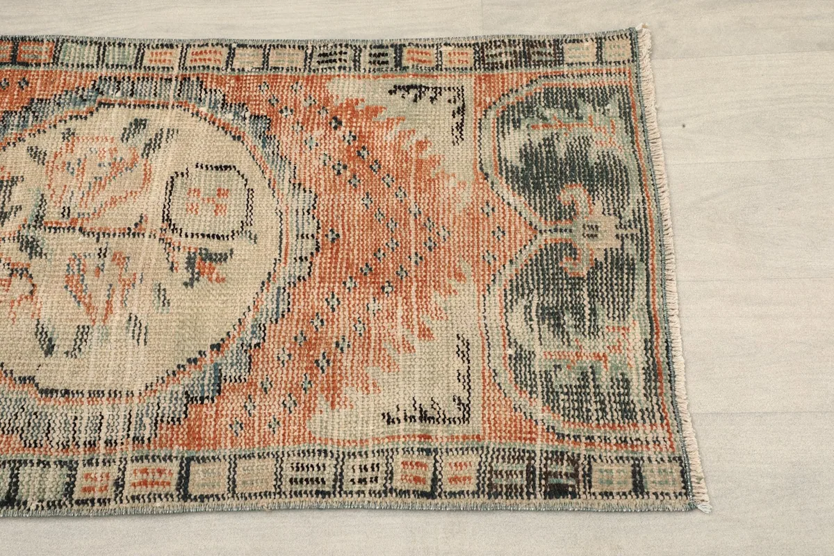 Close-up of the upper right section of the rug, showing rust, gray, and black patterns