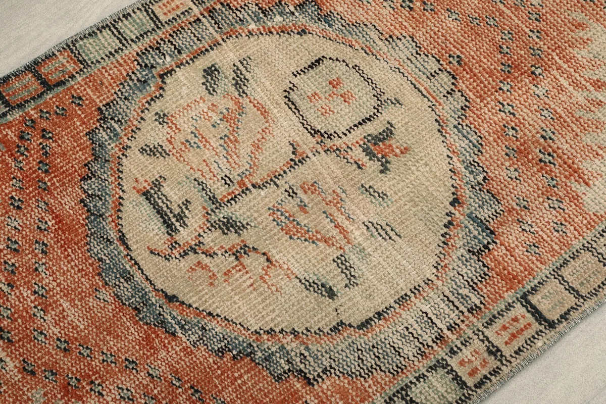 Detail view of the central ivory medallion with faint rust and black patterns