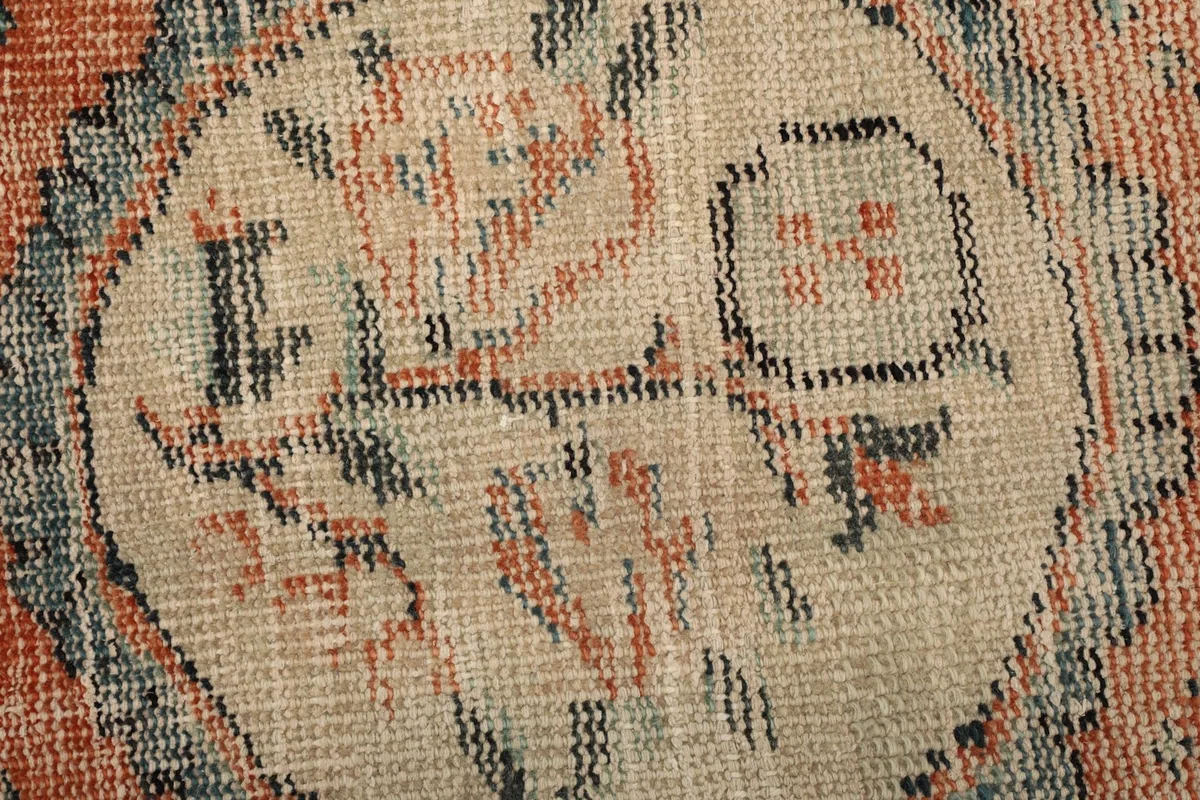Extreme close-up of the rug's low pile, revealing the texture and faded colors