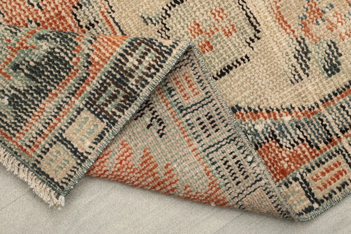 Underside view of the rug, showing the hand-knotted cotton foundation and reverse patterns