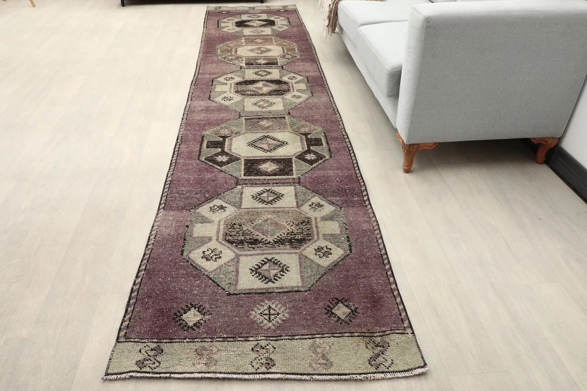 Runner rug featuring rose and black geometric patterns laid in a modern hallway with a light floor