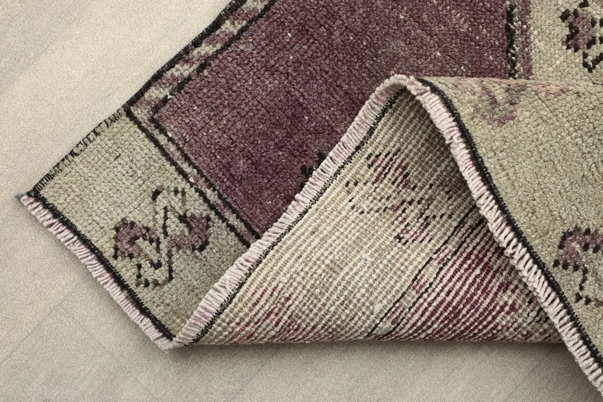 Folded corner of the runner, revealing the cotton foundation and the reverse side of the hand-knotted wool rug