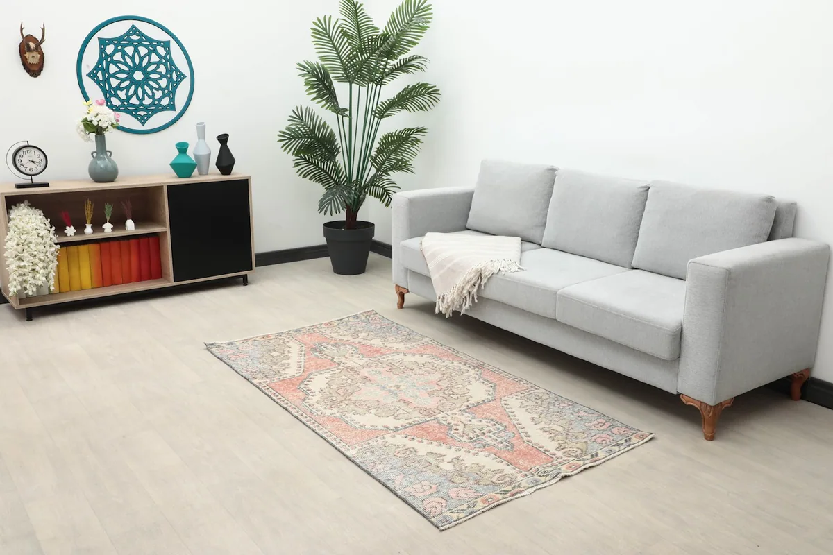 The small rug placed in a living room setting under a sofa, showing scale and decor potential.