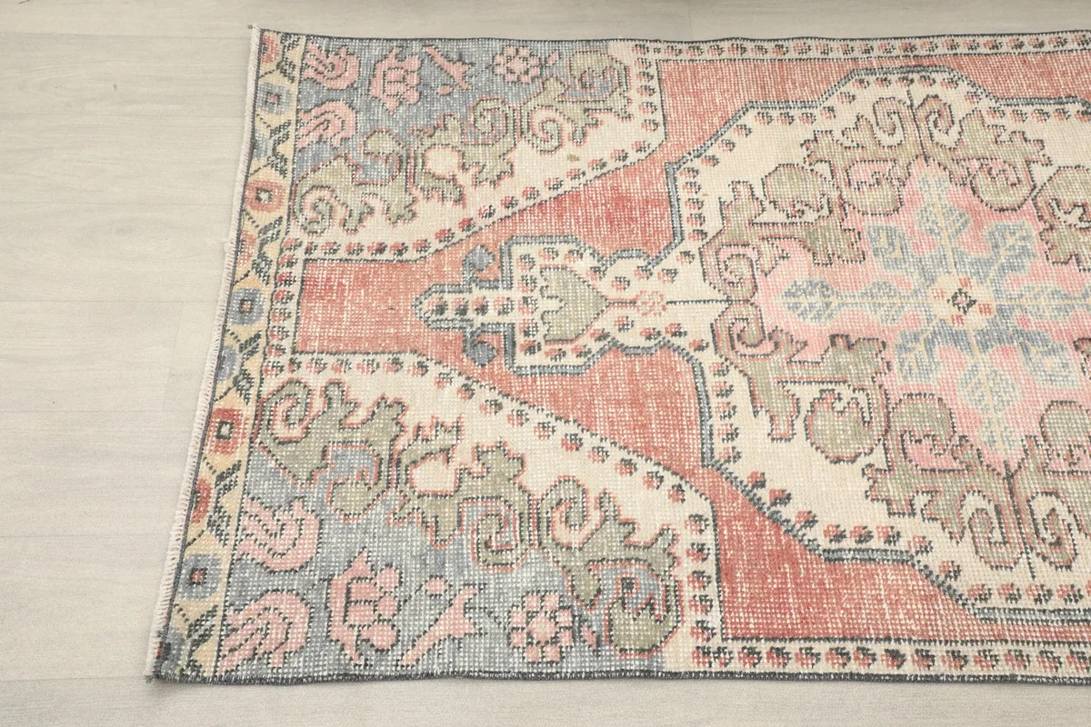 Detail of the rug's blue border with geometric patterns and the corner motifs.